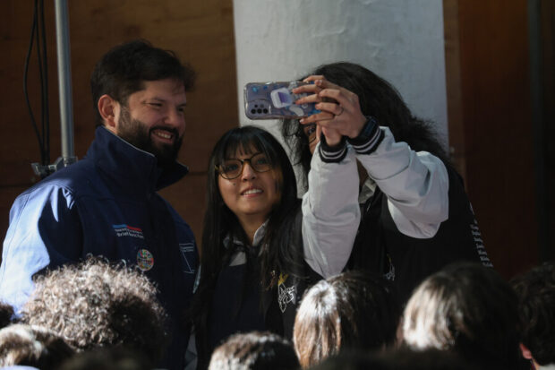 El Presidente Gabriel Boric en la Feria Activa tu Pase Cultural sacándose una selfie con dos alumnas de la comuna de Puente Alto