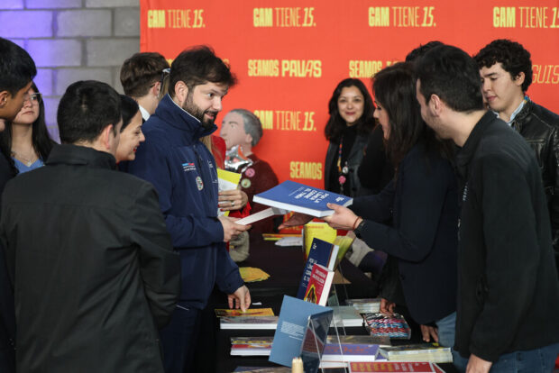 El Presidente Gabriel Boric en la Feria Activa tu Pase Cultural recibiendo un libro. 