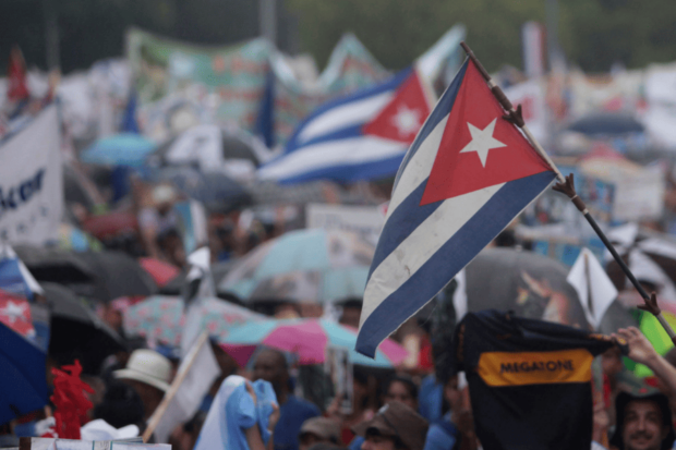 Primer plano de una bandera cubana en medio de una gran multitud.