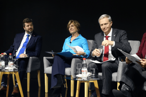 Los candidatos presidenciales, Johannes Kaiser, Evelyn Matthei y José Antonio Kast, sentados en diferentes sillas, uno al lado del otro,.