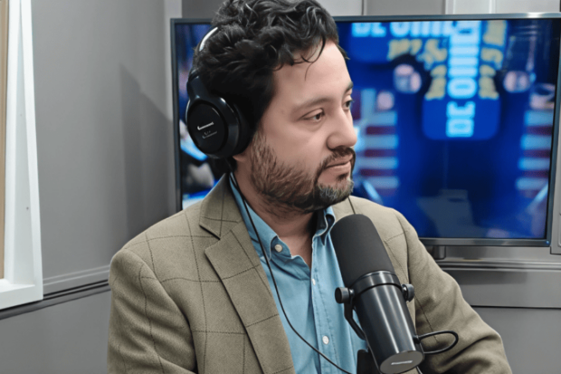 Director ejecutivo de Amnistía Internacional Chile, Rodrigo Busto, en un estudio de radio. Aparece frente a un micrófono y usando audífonos headset.