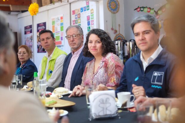 Alcalde de Renca, Claudio Castro, sentado en una mesa con sandwich y tazas junto al biministro de Energía y Economía, Álvaro García, y la ministra de Desarrollo Social y Familia, Javiera Toro. 