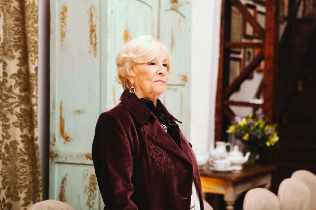 Delfina Guzmán vestida con un traje burdeo.