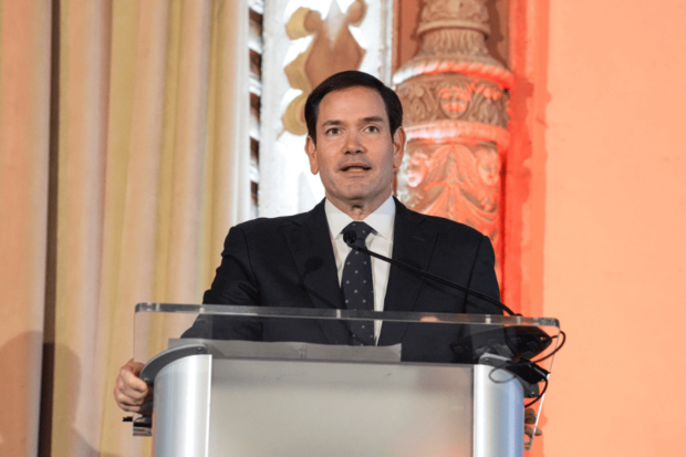 Marco Rubio, secretario de Estado de los Estados Unidos, habla desde un podio gris.