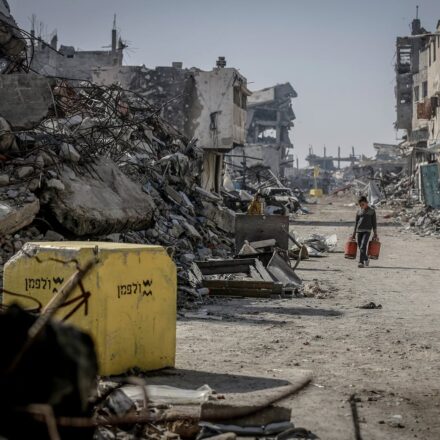 Niño palestino cargando balones de gas en medio de la destrucción de la ciudad. Vía X@Timesofgaza