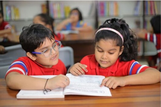 Dos niños leyendo en la sala de clases.