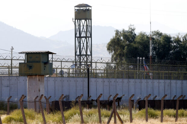 Fotografía en plano medio que muestra parte del muro perimetral y las instalaciones de la cárcel de Punta Peuco.