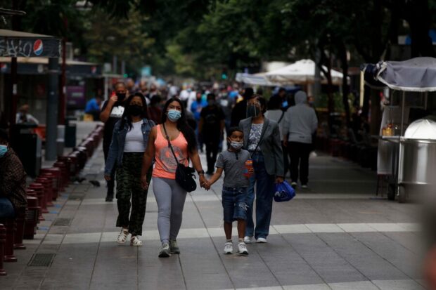 Transeúntes utilizando mascarilla durante la pandemia del COVID.