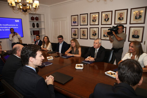 Líderes empresariales sostienen reunión con el equipo económico del presidente electo, José Antonio Kast, en una mesa de madera brillante.