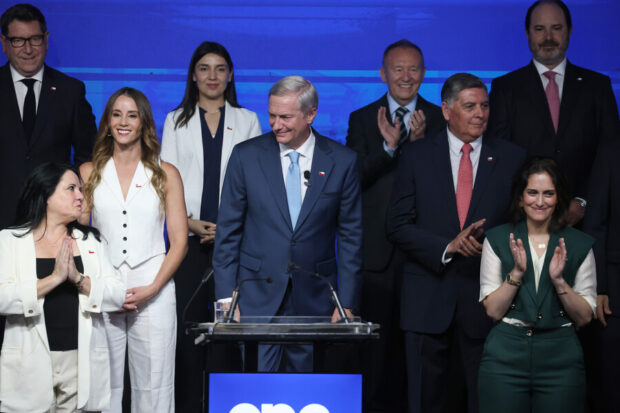 Kas con un grupo de personas ordenadas atrás de él.