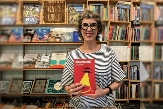 Nona Fernández posa con su libro "Marciano". Detrás de ella un mueble lleno de libros.