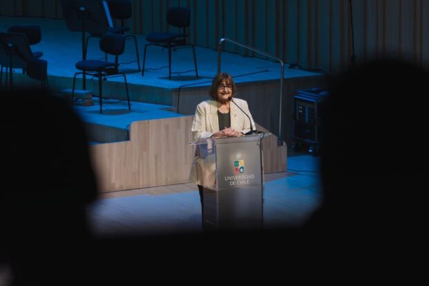 Rectora de la U. de Chile, Rosa Devés, hablando desde un podio con el logo de la Casa de Bello.