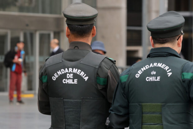 Dos oficiales de Gendarmería de espalda.