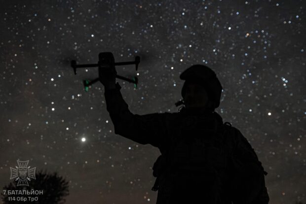 Soldado ucraniano sosteniendo un dron FPV en medio de la noche. Vía X@DefenceU