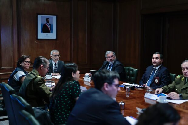 Luis Cordero y Carolina Leitao sentados en una mesa junto a otras autoridades.