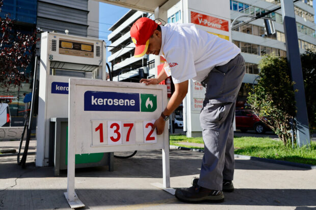 Personal de una estación de servicio Shell ajusta el alza del precio del kerosene.