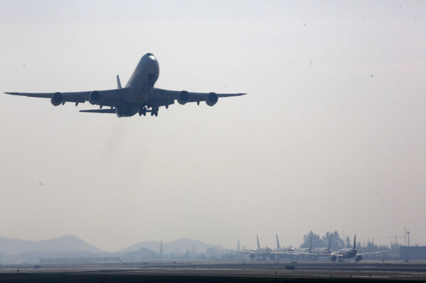 Un avión en el cielo apunto de aterrizar en la pista del aeropuesto.
