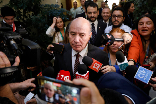 El ministro de Hacienda, Jorge Quiroz, hace ingreso a la Comisión de Hacienda de la Cámara de Diputados totalmente rodeado de periodistas y camarógrafos de distintos medios de comunicación.
