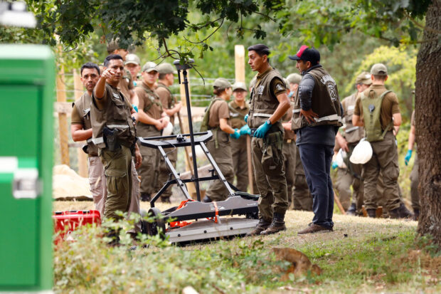 Un grupo de carabineros sostiene equipos de limpieza en terreno de Julia Chuñil.