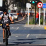 Informe de Conaset respalda ejecución del tercer tramo de la ciclovía en Alameda Hombre pedaleando en la ciclovía Nueva Alameda Providencia. Se ve el ciclista al medio mientras los autos siguen su curso a cada lado de la ciclovía.