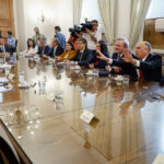 Dirigentes políticos sentados alrededor de una mesa.