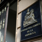 La entrada de un edificio y el placa que indica que es de la Contraloría General de la República.