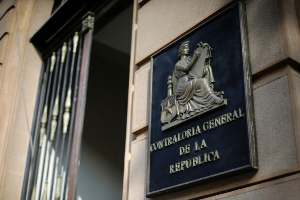 La entrada de un edificio y el placa que indica que es de la Contraloría General de la República.