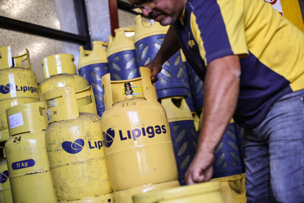 Repartidor de gas recoge balón de gas de 15 kilogramos. 