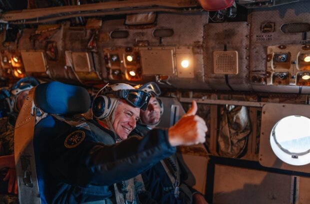 Presidente Kast al interior de una aeronave militar con casco de vuelo y gafas protectoras sonriendo y haciendo el gesto de "pulgar arriba".