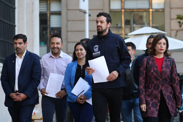 Grupo de alcaldes camina con dirección a La Moneda mientras sostienen una hoja blanca en sus manos.