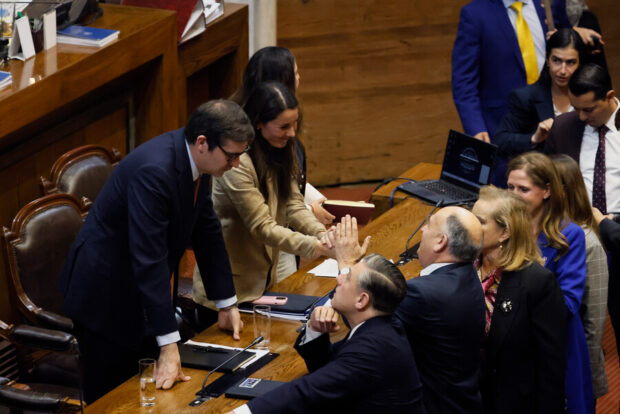Ministros y parlamentarios conversan y se saludan en la testera de la Cámara de Diputadas y Diputados.