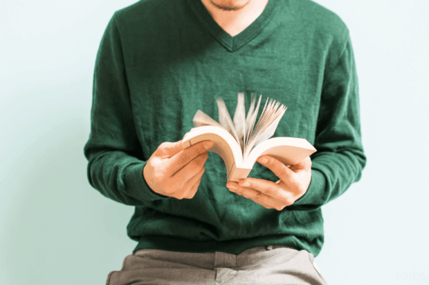 Un hombre hojeando un libro.