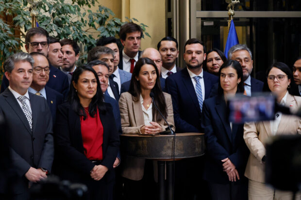 Ministra Arzola habla desde un podio acompañada de al menos 5 diputados que están detrás de ella.