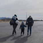 Encuesta Ipsos: 60% cree que Chile se beneficia de la migración y 73% de migrantes declara haber sufrido discriminación Una familia de migrantes caminando por la carretera.