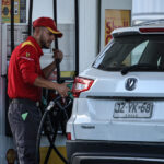 Quiroz anuncia baja en precios de los combustibles tras apertura del estrecho de Ormuz Un trabajador de la Shell se ve sosteniendo la manguera de combustible mientras carga bencina a un vehículo.