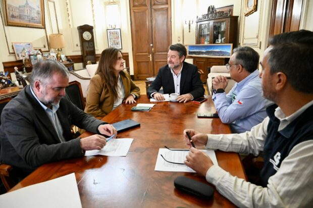 Grupo de autoridades sentadas en una mesa.