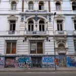 Fachada del Hotel Royal, un edificio patrimonial de estilo neoclásico francés. La parte baja de su fachada está cubierto por grafitis.