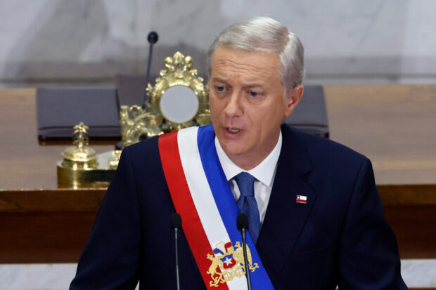 José Antonio Kast entrega discurso vistiendo la banda presidencial desde un podio.