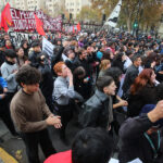 CONFECH tras reunión con Subsecretaría de Educación Superior: “Nada nos asegura que la gratuidad esté a salvo” Multitud de estudiantes marcha entre banderas y carteles con consignas mientras gritan cánticos sobre educación.