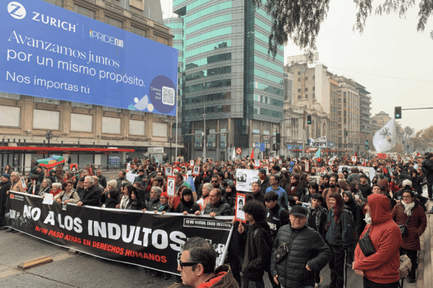 Agrupaciones y ciudadanos portan carteles con rostros de víctimas y un lienzo principal durante la manifestación por los Derechos Humanos.