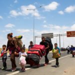 María Emilia Tijoux por reporte de migrantes: “Me hace pensar mucho en los periodos de la dictadura” Familia de migrantes en la frontera Chile-Perú. Los padres llevan grandes maletas y sostienen a sus hijos pequeños de la manos.