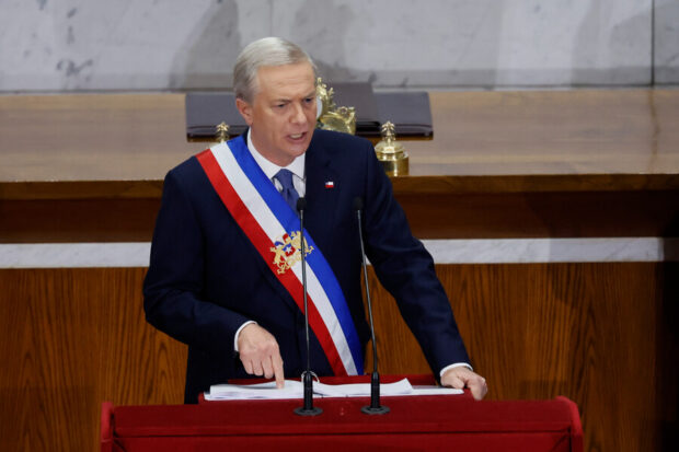 José Antonio Kast entrega discurso vistiendo la banda presidencial desde un podio.