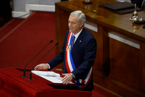 José Antonio Kast entrega discurso vistiendo la banda presidencial desde un podio.