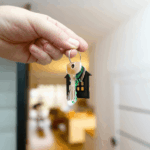 Fondo de garantía estatal para viviendas: Kast propone elevar hasta 4 mil UF las postulaciones para la clase media Mano sosteniendo las llaves de una nueva casa con un llavero en forma de hogar, con el interior difuminado de fondo.