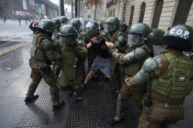 Un grupo de al menos 10 carabineros reducen y detienen a joven en el marco de la movilización estudiantil convocado por la CONFECH.